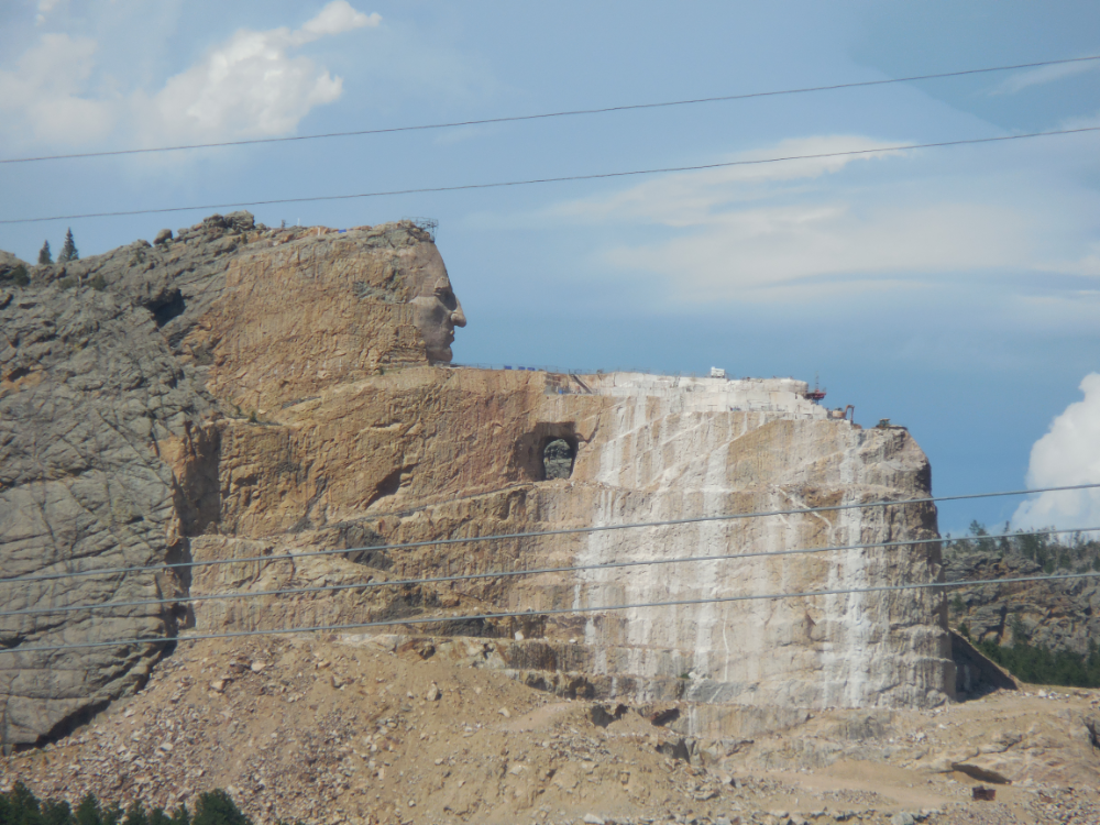 Crazy Horse. Started before Mt Rushmore but not funded by the government and 10 times the size.